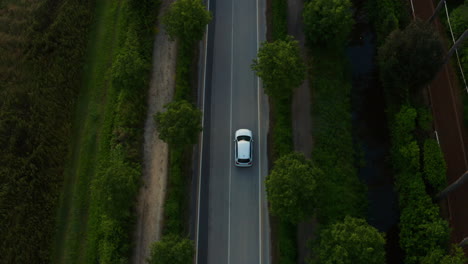 行驶在山间空旷道路上的白色汽车
