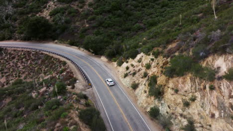 行驶在山间蜿蜒道路上的白色汽车