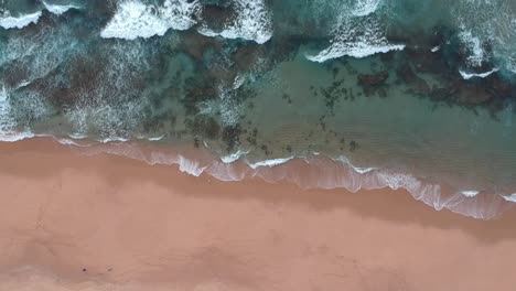 清澈的海浪拍打着棕色的海滩