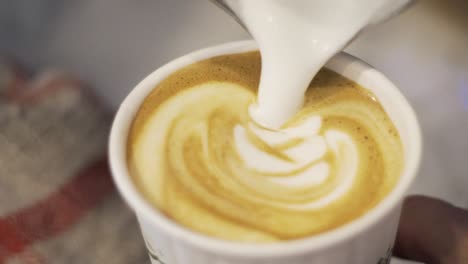 往咖啡里倒入牛奶并制作拉花