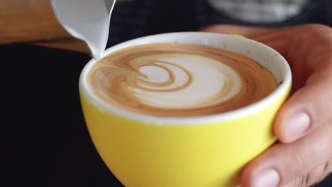 往咖啡里倒入牛奶并制作简单的拉花